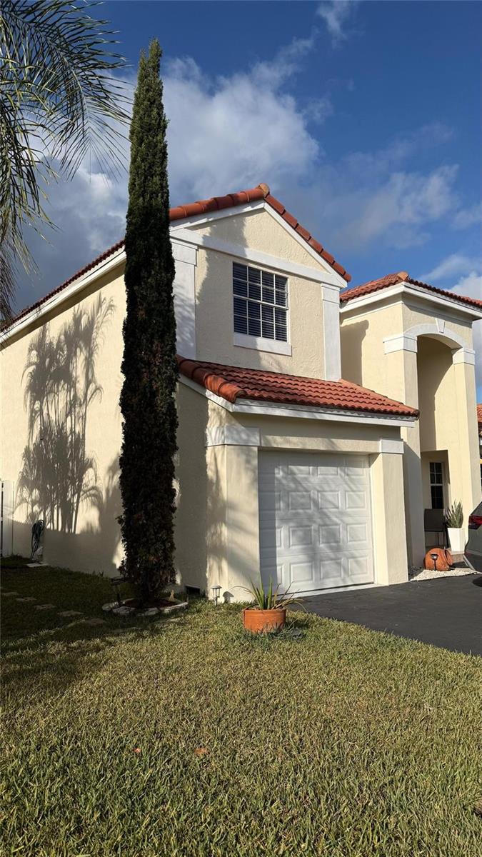 A two-story house with a tan stucco exterior, a red tile roof, and a single-car garage — 593 Bedford Avenue, Weston FL 33326, WESTON, FL