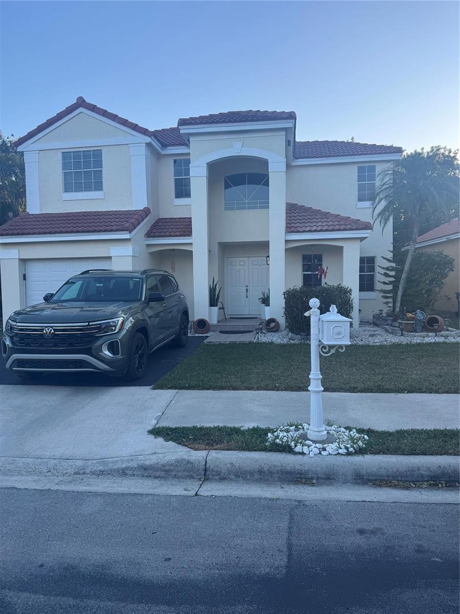 A two-story stucco house with a tile roof, a front-facing garage, and a white mailbox — 593 Bedford Avenue, Weston FL 33326, WESTON, FL