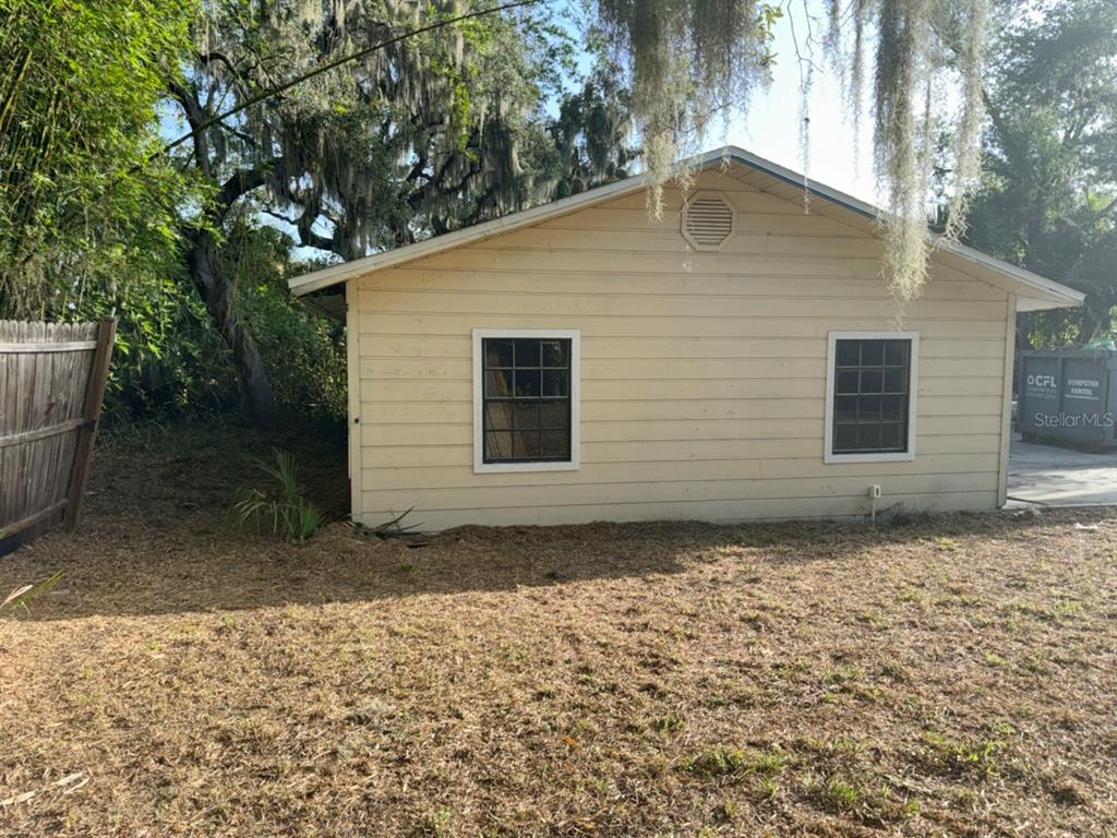 The exterior of a light-colored, single-story building with two windows and a gable roof — 9901 DAVIS STREET, GIBSONTON, FL