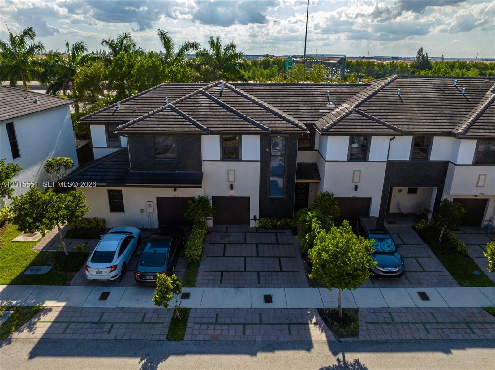 An aerial view shows a multi-unit townhouse complex with driveways and parked cars — 15776 NW 91st Ct, Miami Lakes FL 33018, MIAMI LAKES, FL