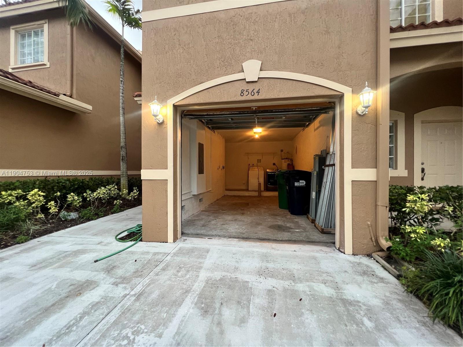 An open residential garage with a concrete floor and a light fixture on the ceiling — 8564 SW 214th Way, Cutler Bay FL 33189, CUTLER BAY, FL