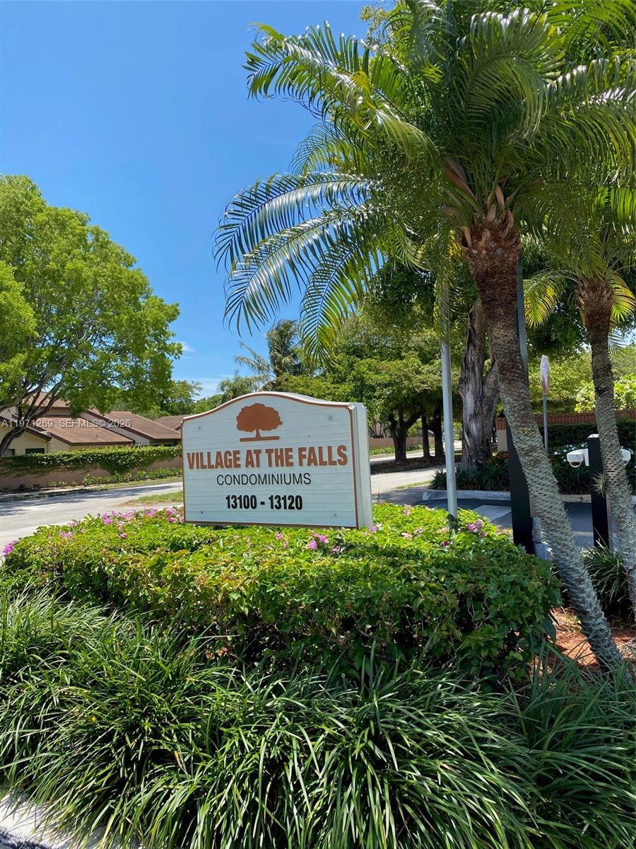 A sign for Village at the Falls Condominiums stands in front of lush landscaping — 13120 SW 92nd Ave # 414, Miami FL 33176, MIAMI, FL