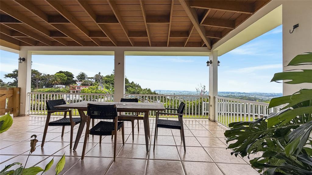 A covered outdoor patio features a wooden ceiling, tiled floor, and a scenic hillside view — PR-839 LOT 9, KM 6.7 ALTOS DE CAMARONES, GUAYNABO, PR