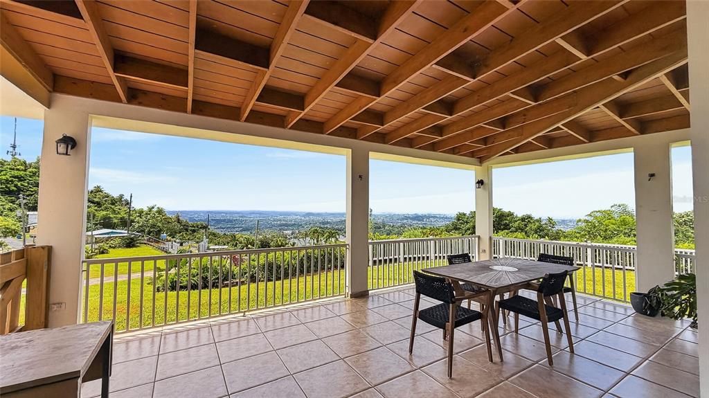 A covered outdoor patio features tiled flooring, a wooden ceiling, and a scenic valley view — PR-839 LOT 9, KM 6.7 ALTOS DE CAMARONES, GUAYNABO, PR