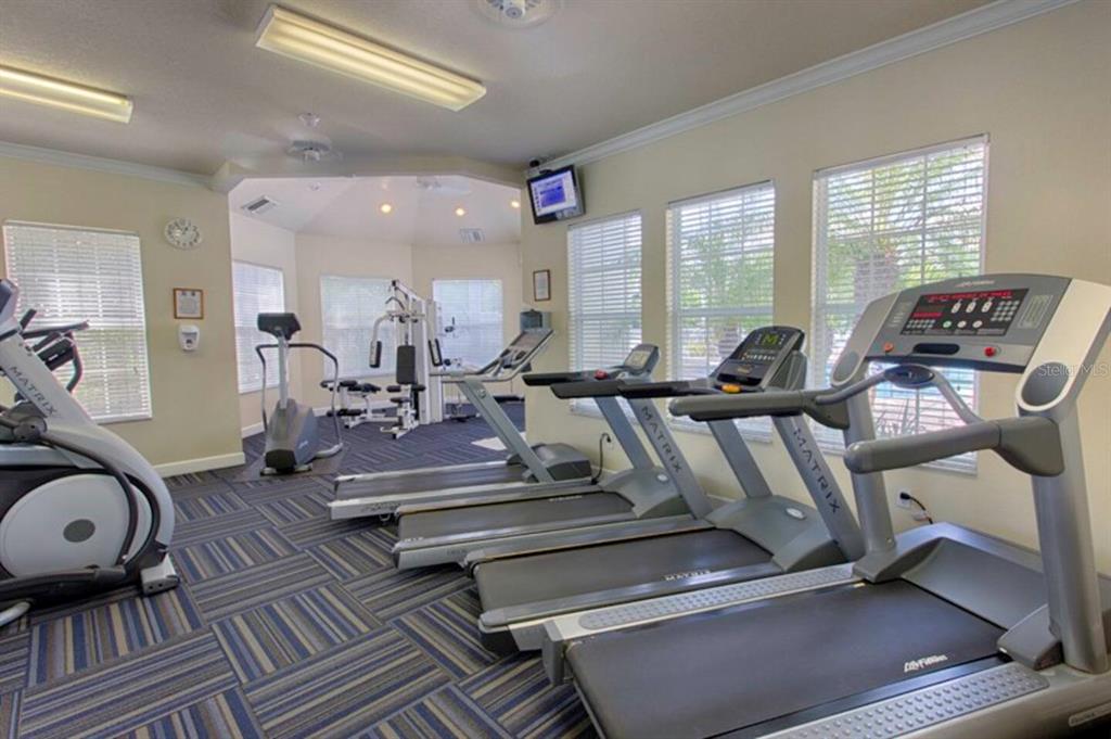 A fitness room features several treadmills, an elliptical machine, and a multi-station weight machine — 8100 PRINCESS PALM LANE UNIT 203, KISSIMMEE, FL