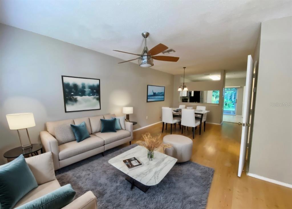 A dining area features light wood flooring, a hanging light fixture, and a staircase — 12415 BERKELEY SQUARE DRIVE, TAMPA, FL