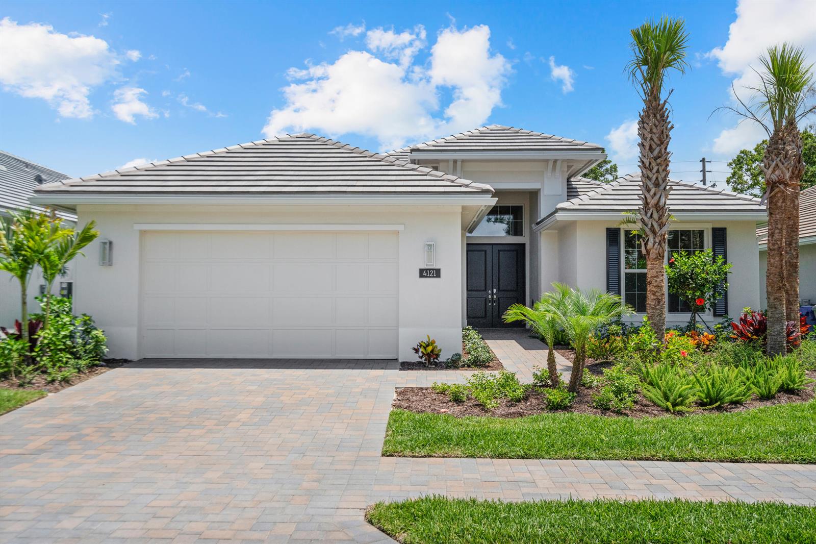 A single-story house with a white exterior, gray tiled roof, and a paved driveway — 4121 Lucaya Pointe Way, Vero Beach FL 32967, VERO BEACH, FL