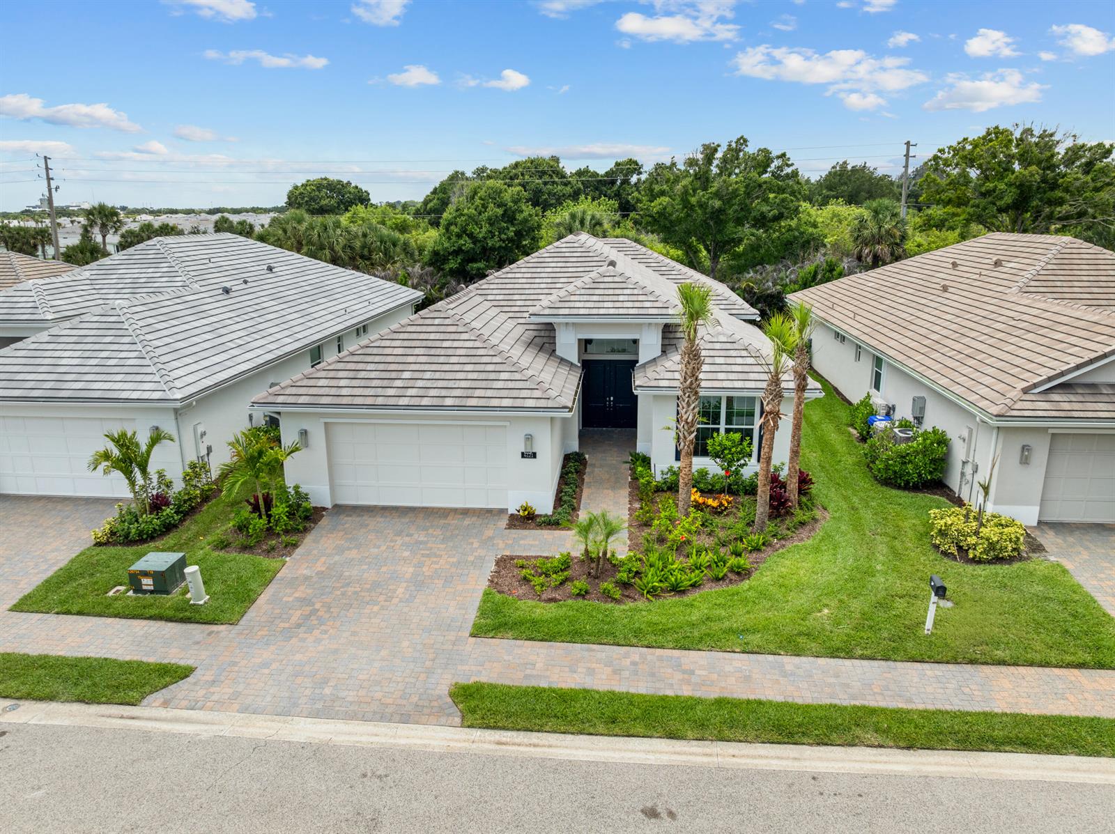 An aerial view shows a single-story house with a tiled roof and a paved driveway — 4121 Lucaya Pointe Way, Vero Beach FL 32967, VERO BEACH, FL