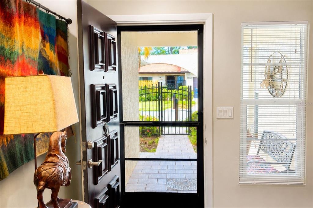 An open front door reveals a tiled entryway and a gated exterior walkway — 3610 NARANJA WAY UNIT 8510, SARASOTA, FL