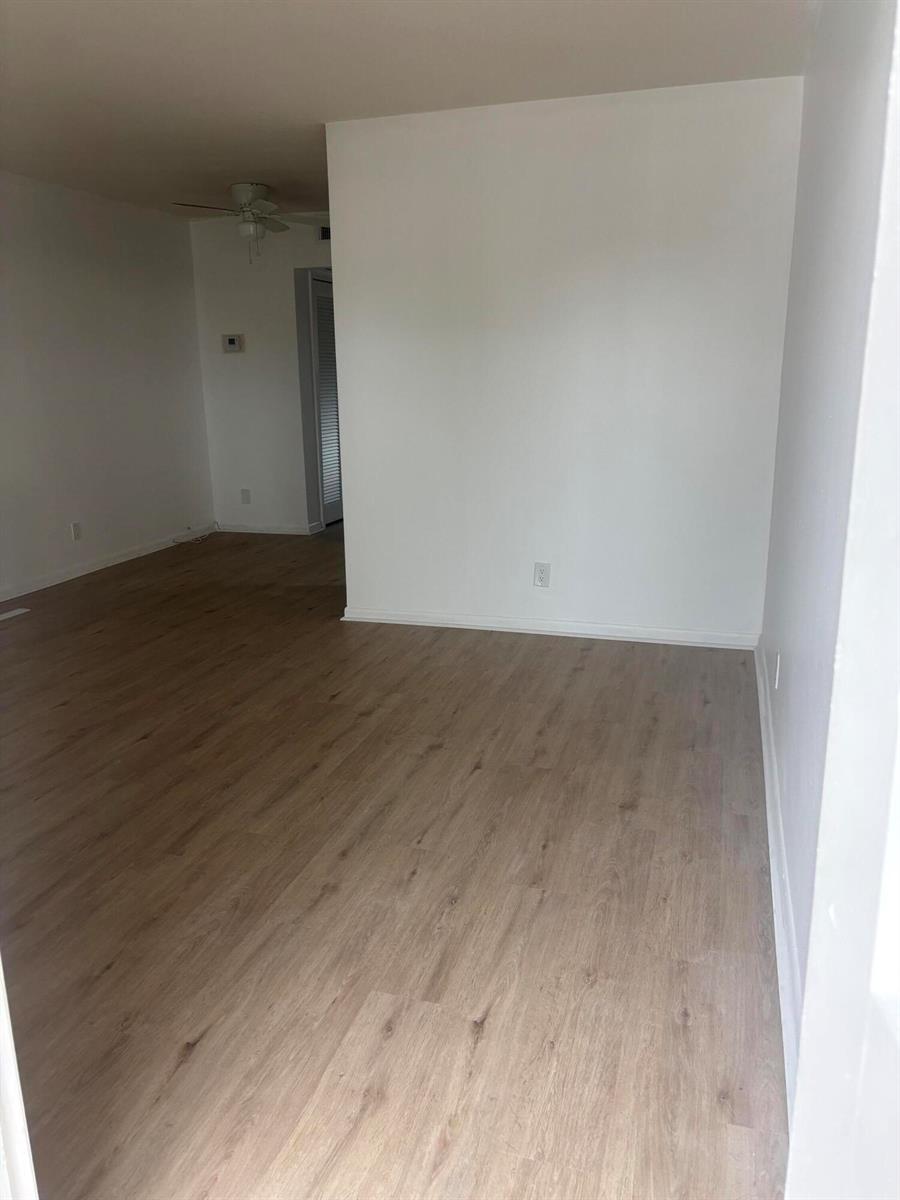 An empty room with light wood-look flooring and white walls — 521 NE 45th Street, Boca Raton FL 33431, BOCA RATON, FL