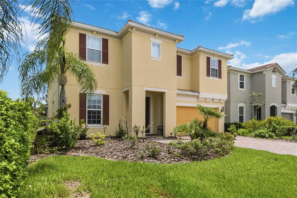 A two-story yellow stucco house with brown shutters and a two-car garage — 12130 ULETA LANE, ORLANDO, FL
