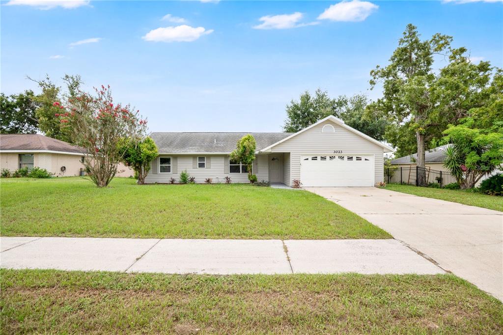 A single-story house with light-colored siding, a two-car garage, and a front lawn — 3023 INDIA BOULEVARD, DELTONA, FL