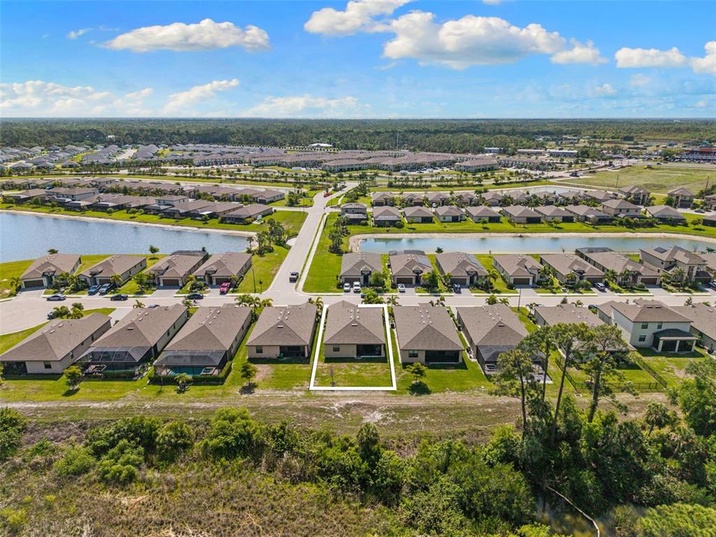 An aerial view shows a residential neighborhood with a highlighted house backing onto woods — 1842 W ISLES ROAD, PORT CHARLOTTE, FL