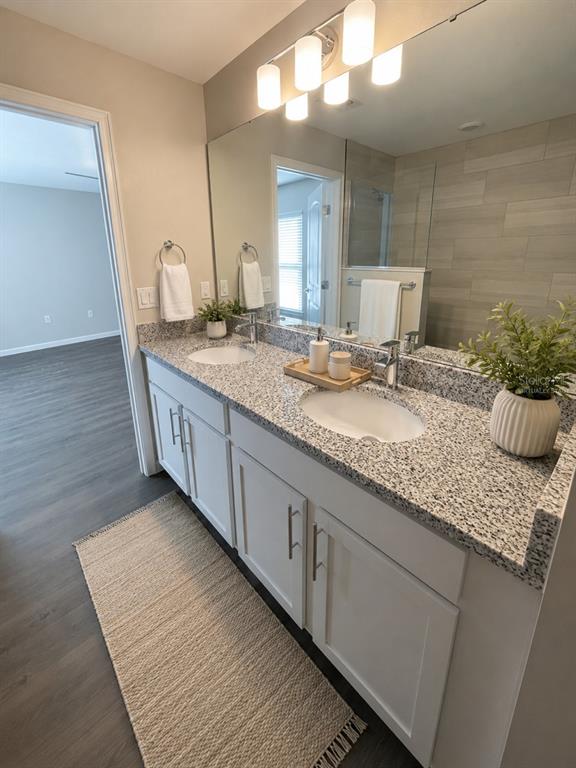 A bathroom features a double vanity with white cabinets, granite countertops, and a large mirror — 4 LEMA PLACE, PALM COAST, FL