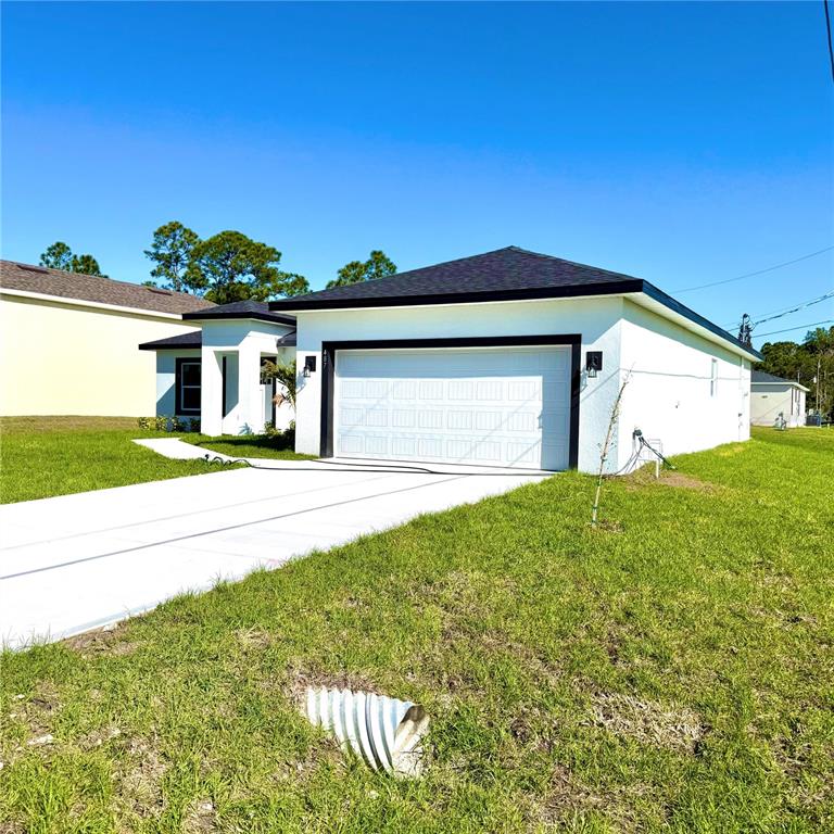 A white single-story house with a two-car garage and a concrete driveway — 487 ALAMO STREET SE, PALM BAY, FL