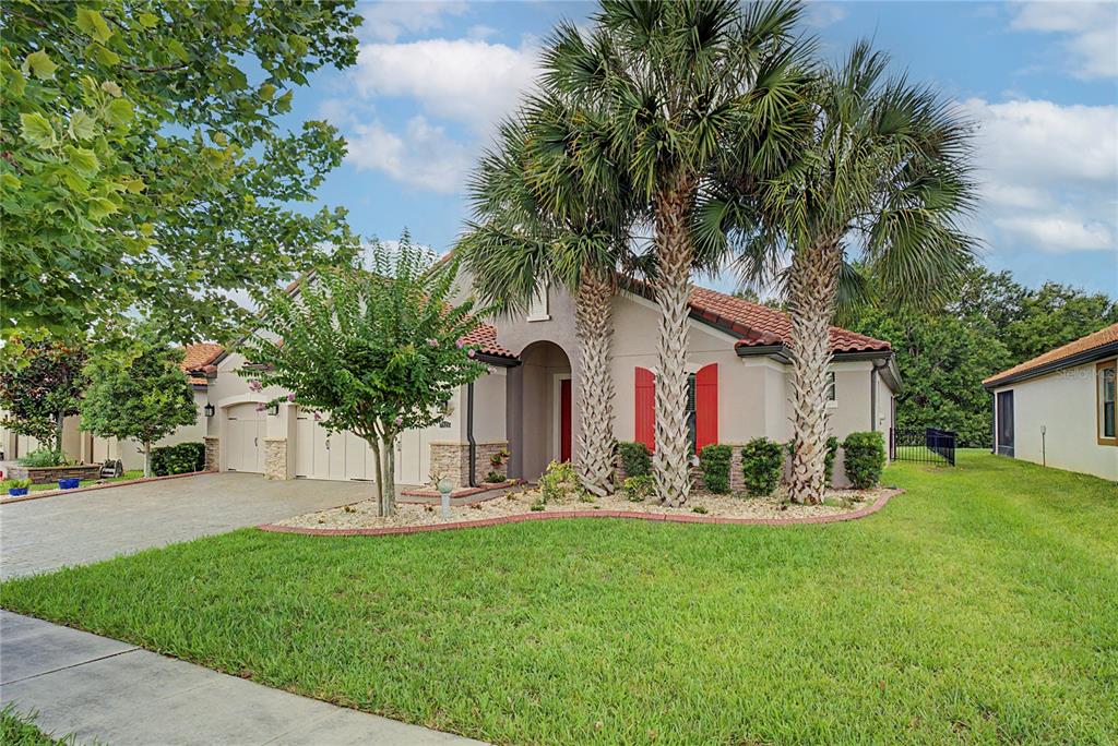 A single-story house with a beige exterior, red shutters, and palm trees in the front yard — 3820 BOWFIN TRAIL, KISSIMMEE, FL