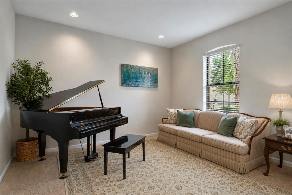 A living room features a black grand piano, a beige sofa, and a patterned area rug — 3820 BOWFIN TRAIL, KISSIMMEE, FL