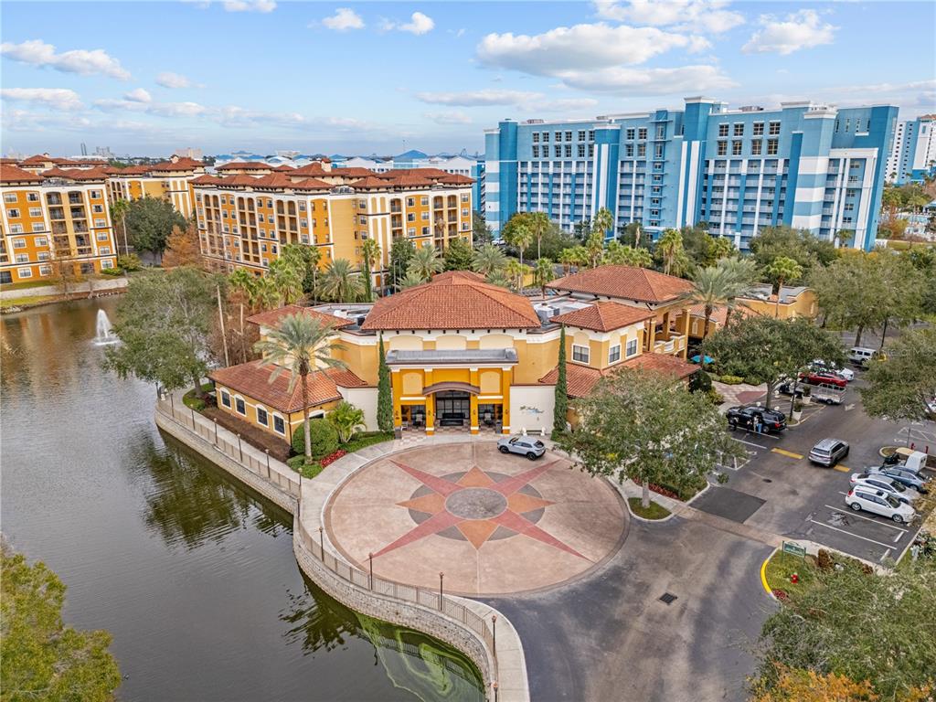 An aerial view shows a resort building with a circular driveway and a nearby lake — 12544 FLORIDAYS RESORT DRIVE, ORLANDO, FL
