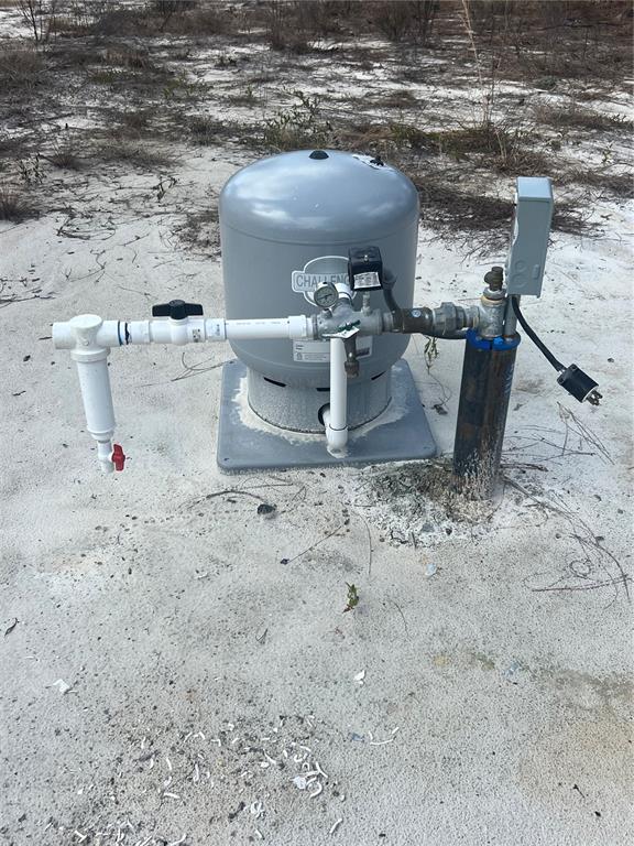 A well pump and pressure tank sit on a concrete pad in a sandy area — 0000 SE 135TH COURT SE, DUNNELLON, FL