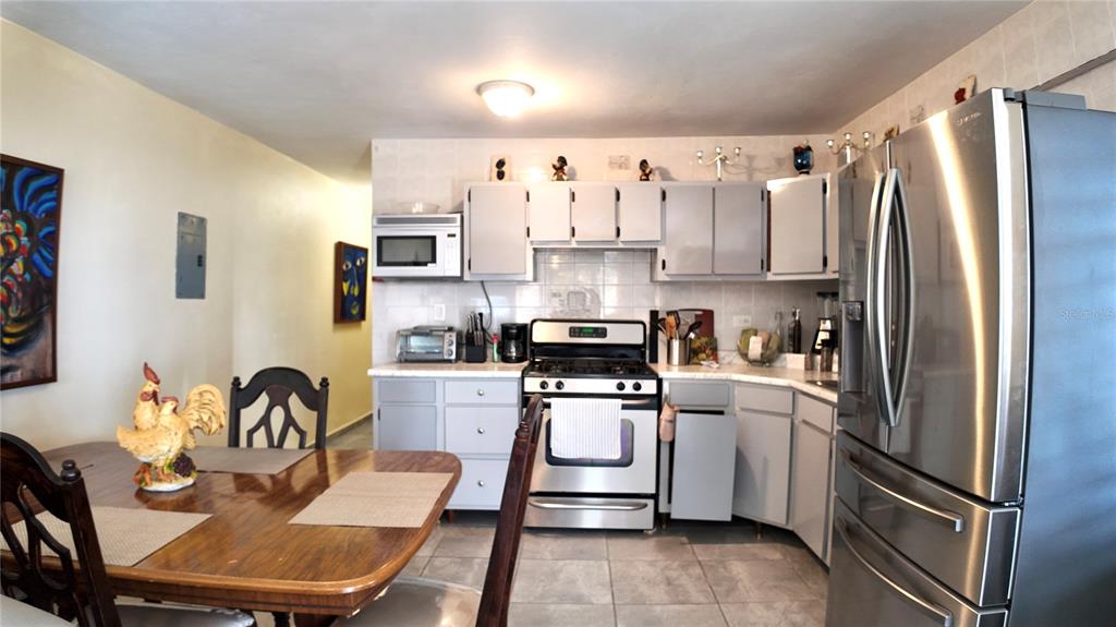 A kitchen features light gray cabinets, stainless steel appliances, and an adjacent wooden dining table — Buzon 6312 Bo. Jaguay CARR. 412 KM 6.0, RINCON, PR