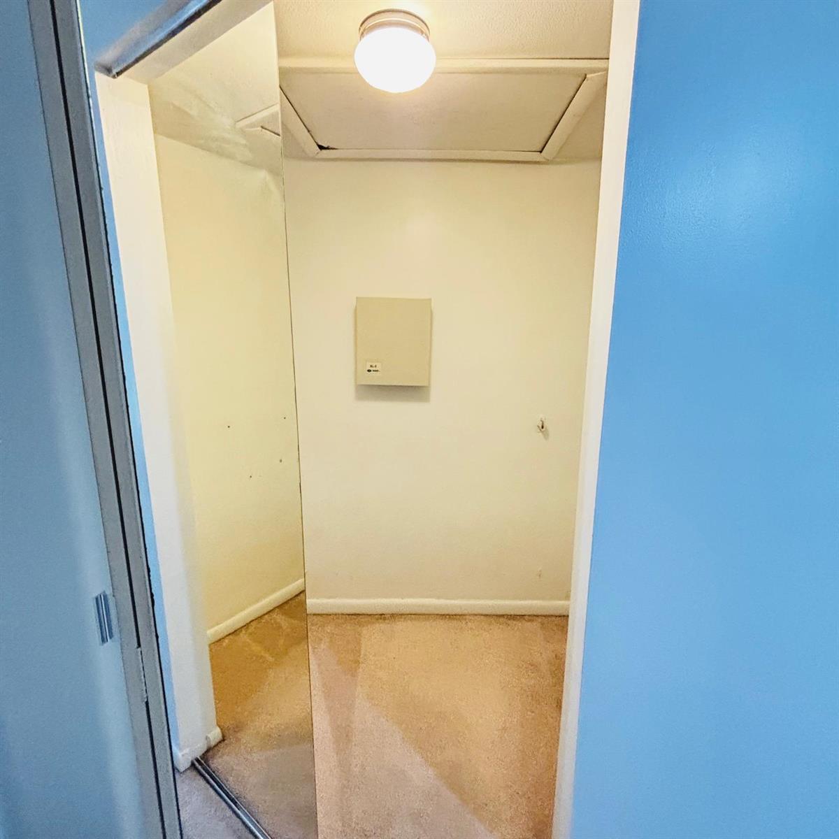 A small carpeted closet features a ceiling light, an attic access panel, and a wall-mounted panel — 386 Bennington Lane, Lake Worth FL 33467, LAKE WORTH, FL