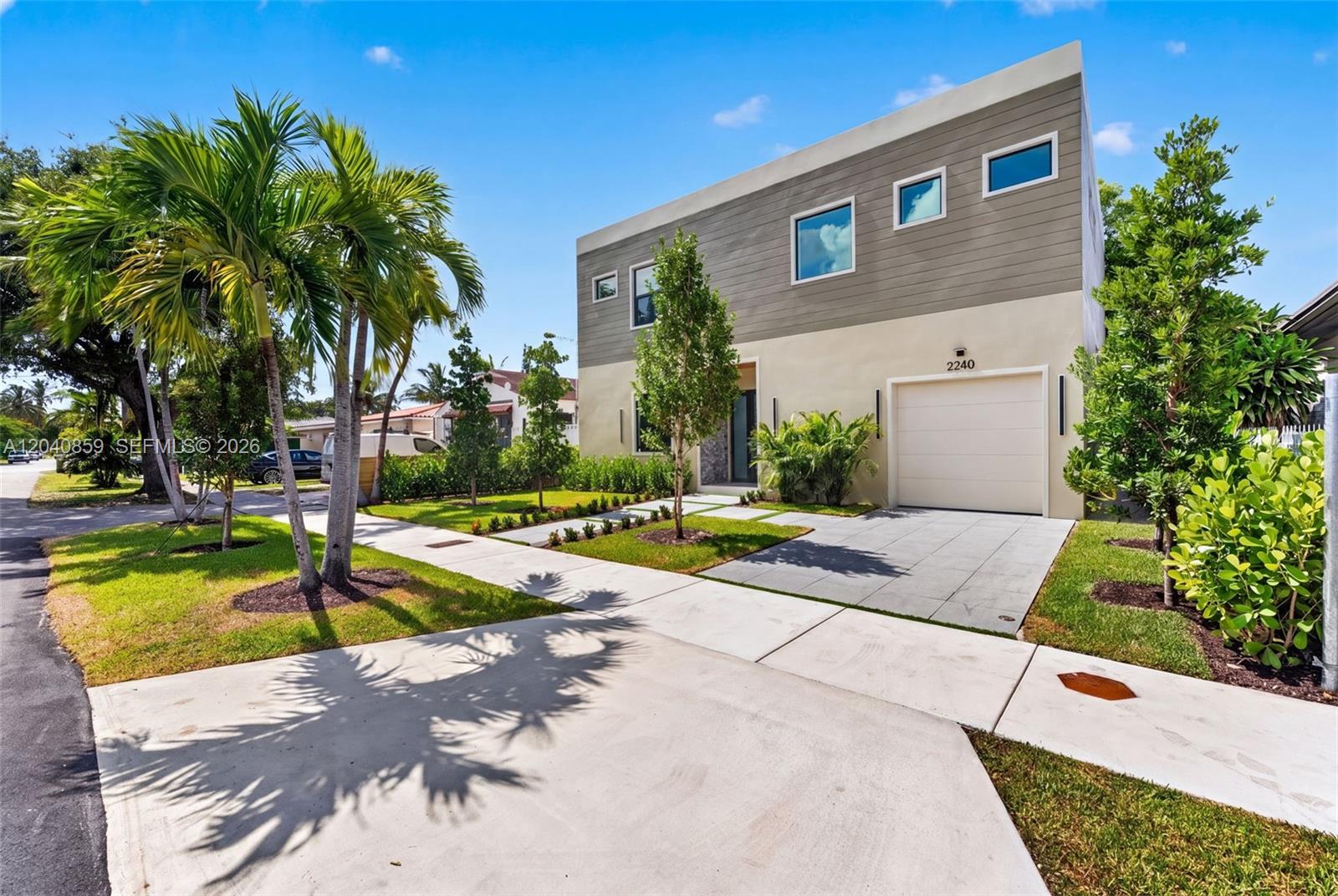 A modern two-story house features a beige lower level, gray siding above, and a garage — 2240 SW 13th St, Miami FL 33145, MIAMI, FL