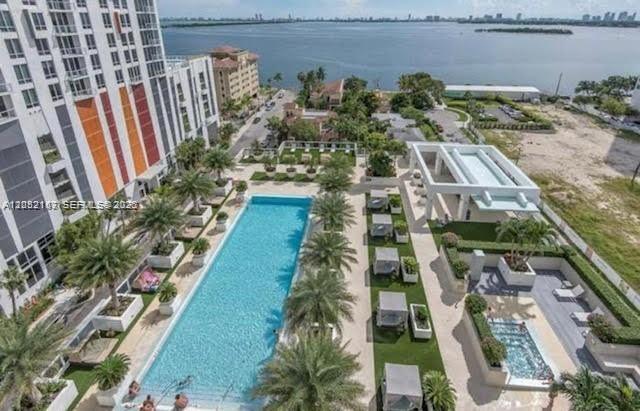 An aerial view of a long swimming pool and patio area beside a tall building — 600 NE 27th St # 2202, Miami FL 33137, MIAMI, FL