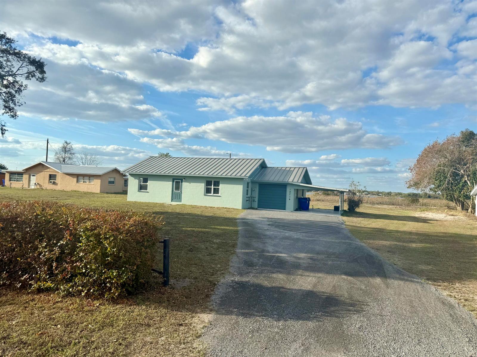 A light green single-story house with a metal roof and a gravel driveway — 12714 U.s. 98, Sebring FL 33876, SEBRING, FL