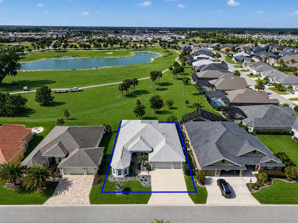An aerial view shows a single-story house with a grey roof and a concrete driveway — 2165 GORDON PATH, THE VILLAGES, FL