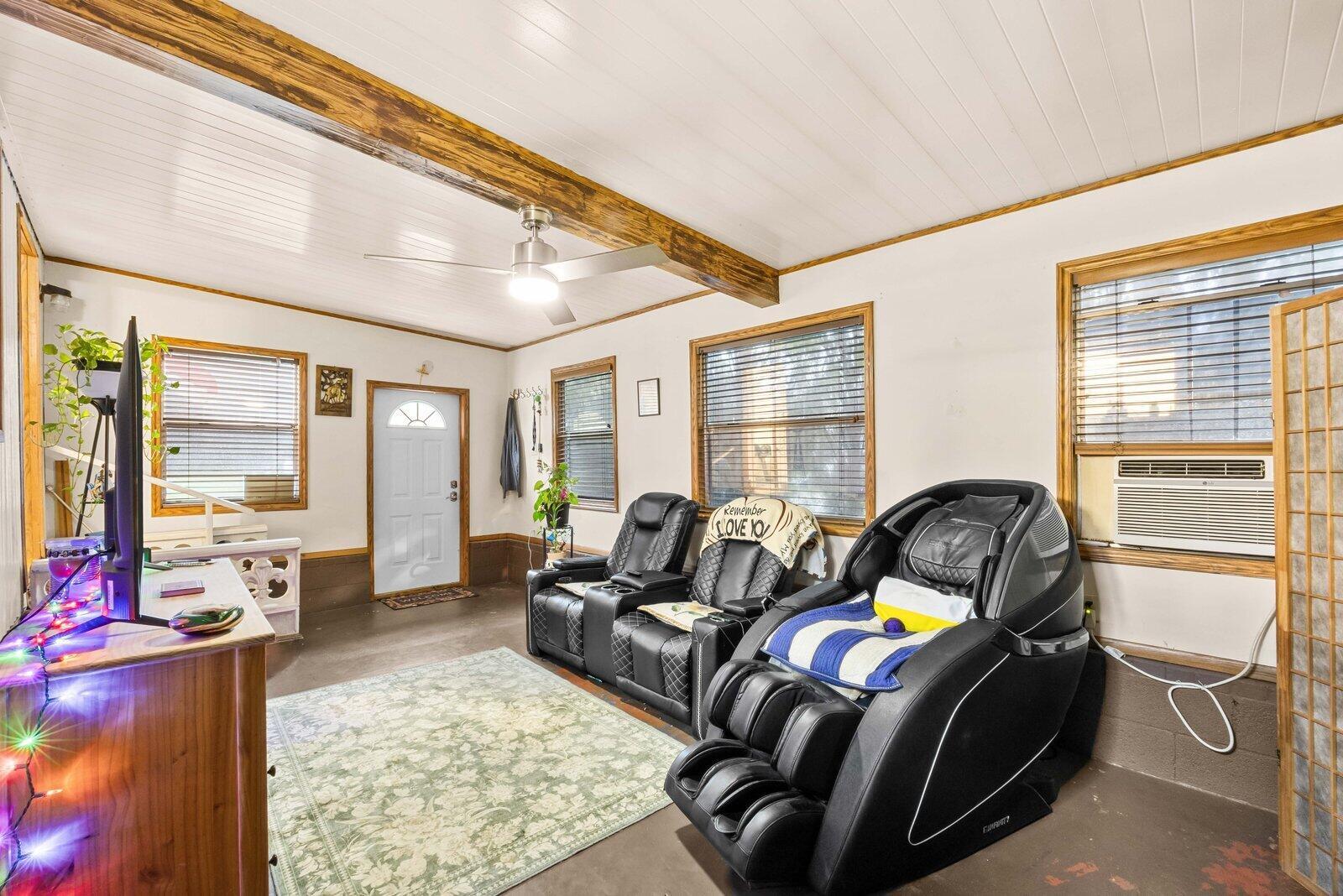 A living room features a ceiling fan, wood-paneled ceiling, two black recliners, and a massage chair — 5985 SE 94TH Trail, Okeechobee FL 34974, OKEECHOBEE, FL