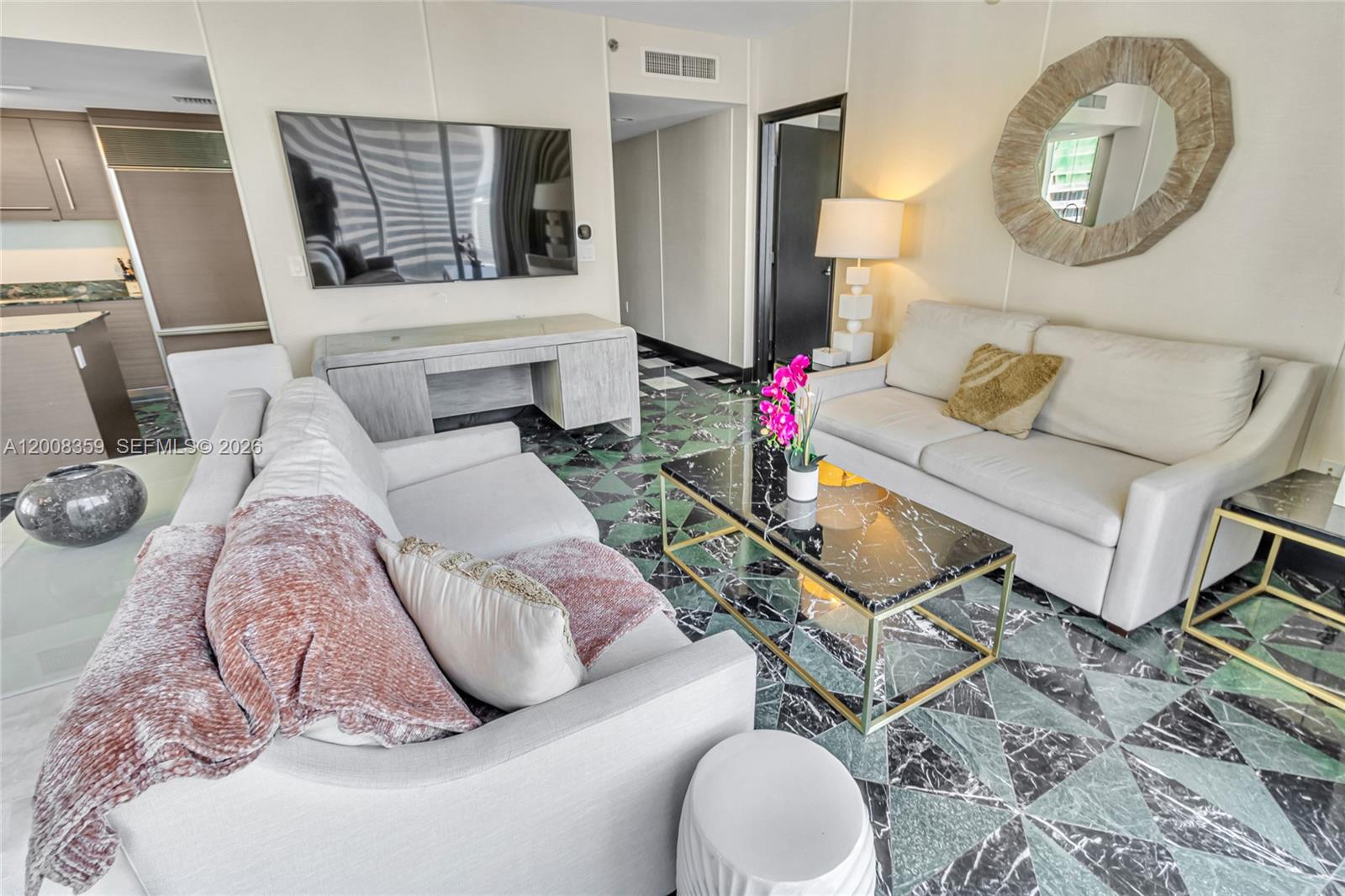 A living room features two white sofas, a marble coffee table, and green patterned flooring — 485 Brickell Ave # 2508, Miami FL 33131, MIAMI, FL