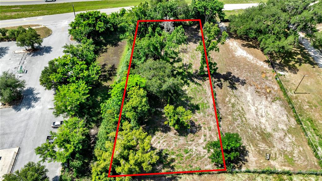 An aerial view shows a rectangular plot of land outlined in red near a parking lot — 9926 ROCKHILL ROAD, THONOTOSASSA, FL