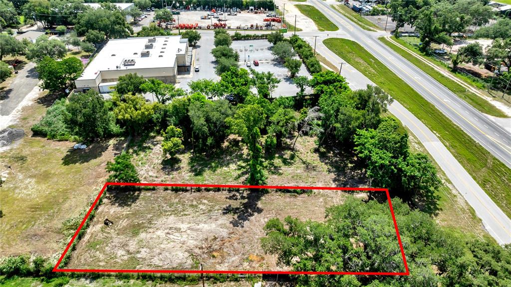 An aerial view shows a rectangular vacant lot outlined in red next to a commercial building — 9926 ROCKHILL ROAD, THONOTOSASSA, FL