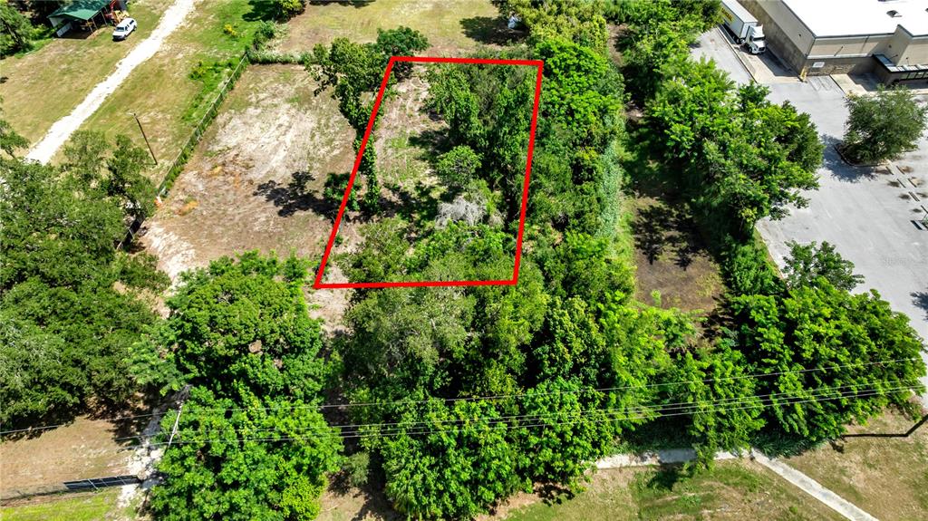 An aerial view shows a rectangular plot of land outlined in red near a building — 9926 ROCKHILL ROAD, THONOTOSASSA, FL