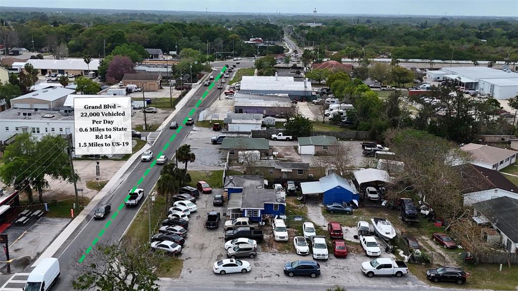 An aerial view shows a commercial property with a parking lot next to a road — 4131 GRAND BOULEVARD, NEW PORT RICHEY, FL