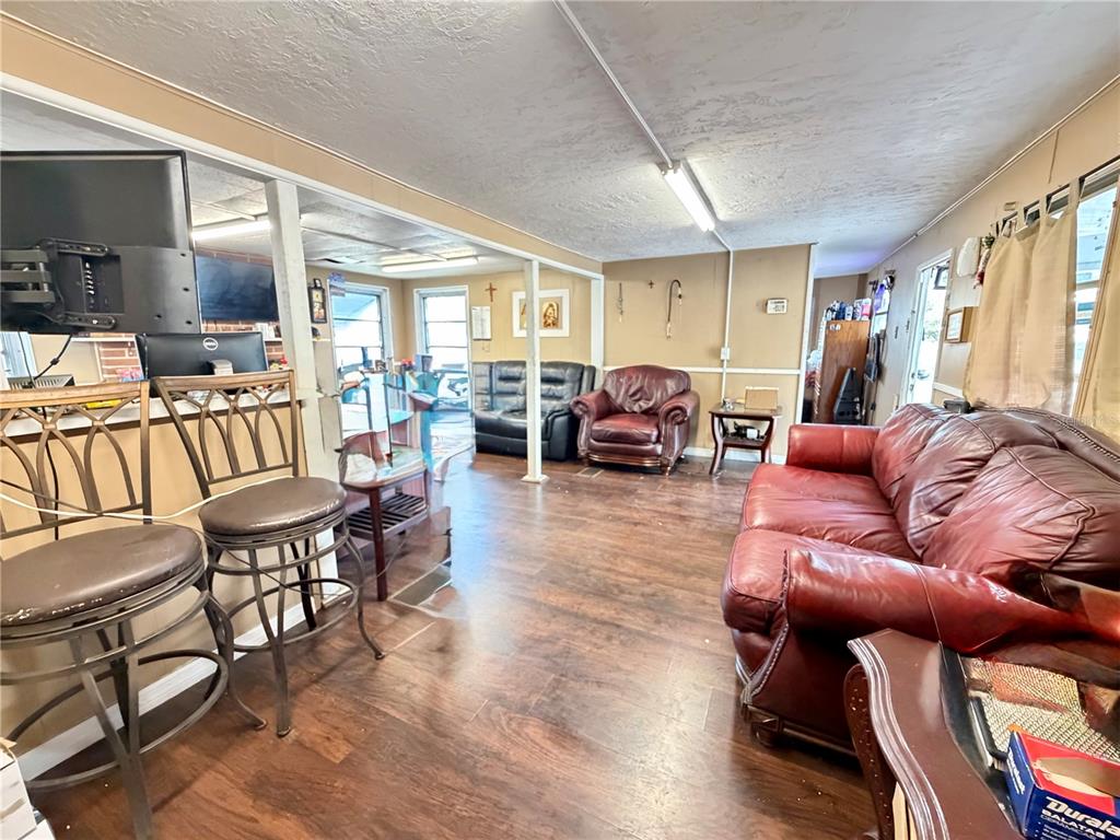 A living room features wood-look flooring, a red leather sofa, and a breakfast bar area — 4131 GRAND BOULEVARD, NEW PORT RICHEY, FL