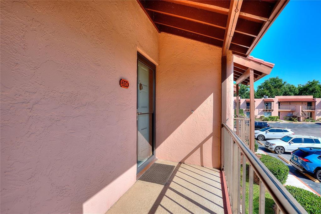 An exterior view of a second-story balcony with a door labeled 206 — 206 LA CASA UNIT 206, LAKE WALES, FL