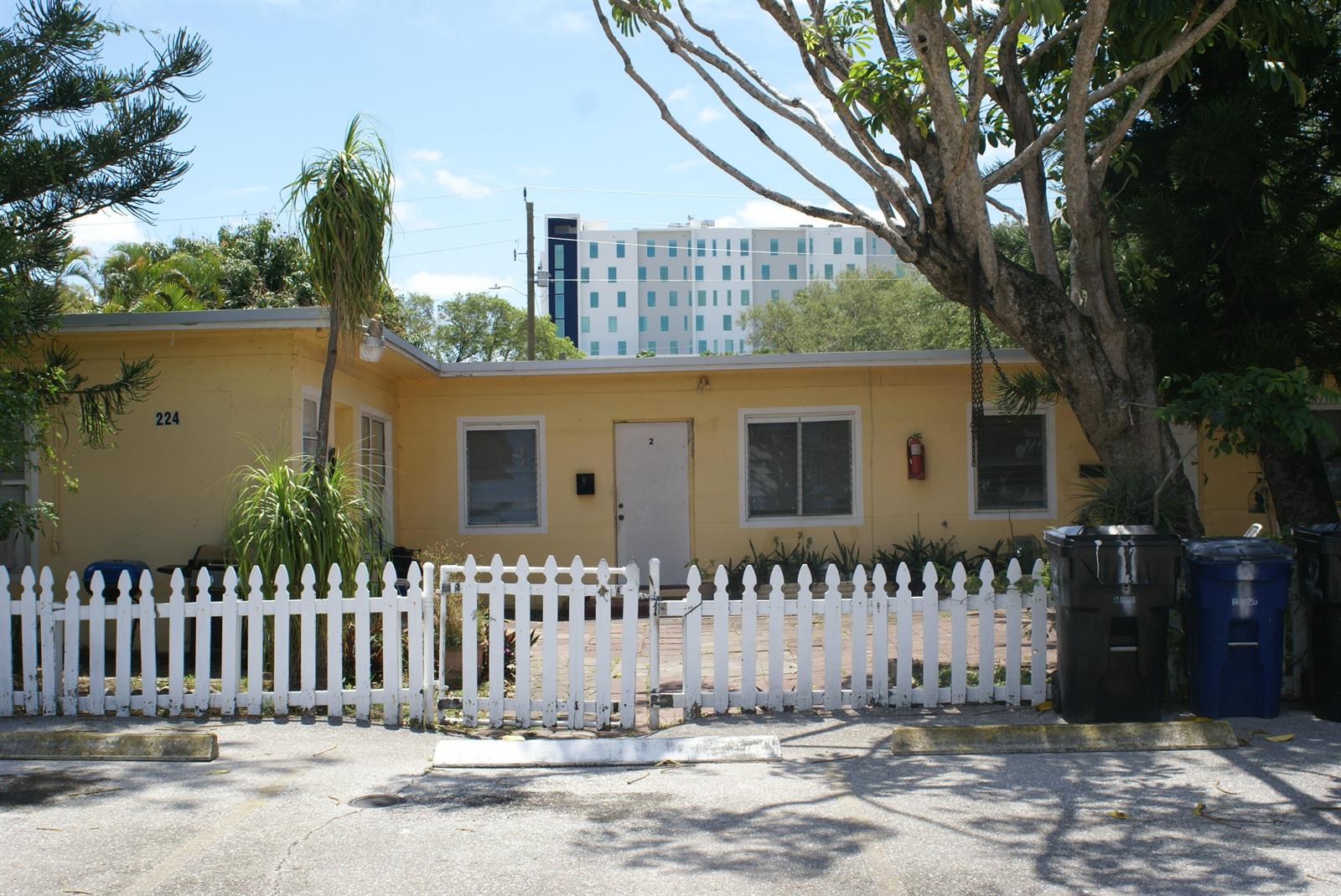 A yellow single-story building with a white picket fence and a paved front patio — 224 SE 9th Court # 4, Hallandale Beach FL 33009, HALLANDALE BEACH, FL