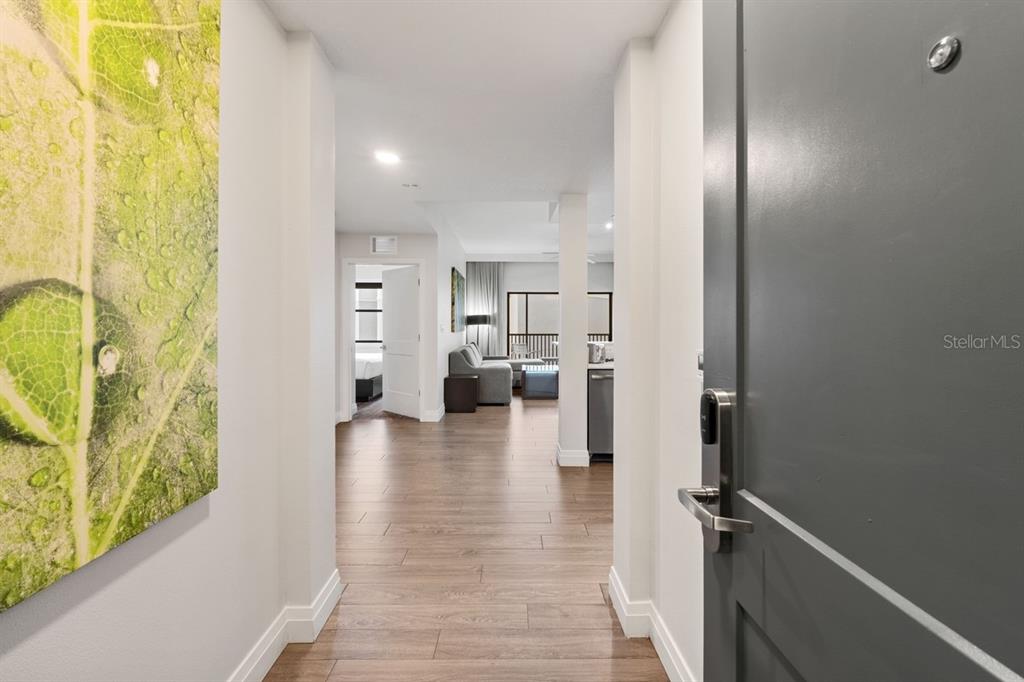 A view from an entryway looking into an apartment with wood-look flooring and white walls — 14501 GROVE RESORT AVENUE UNIT 2607, WINTER GARDEN, FL