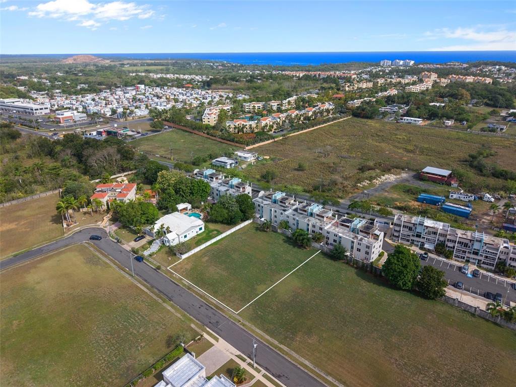 An aerial view shows a vacant rectangular plot of land bordered by residential buildings and roads — G8 CALLE 2, VEGA ALTA, PR