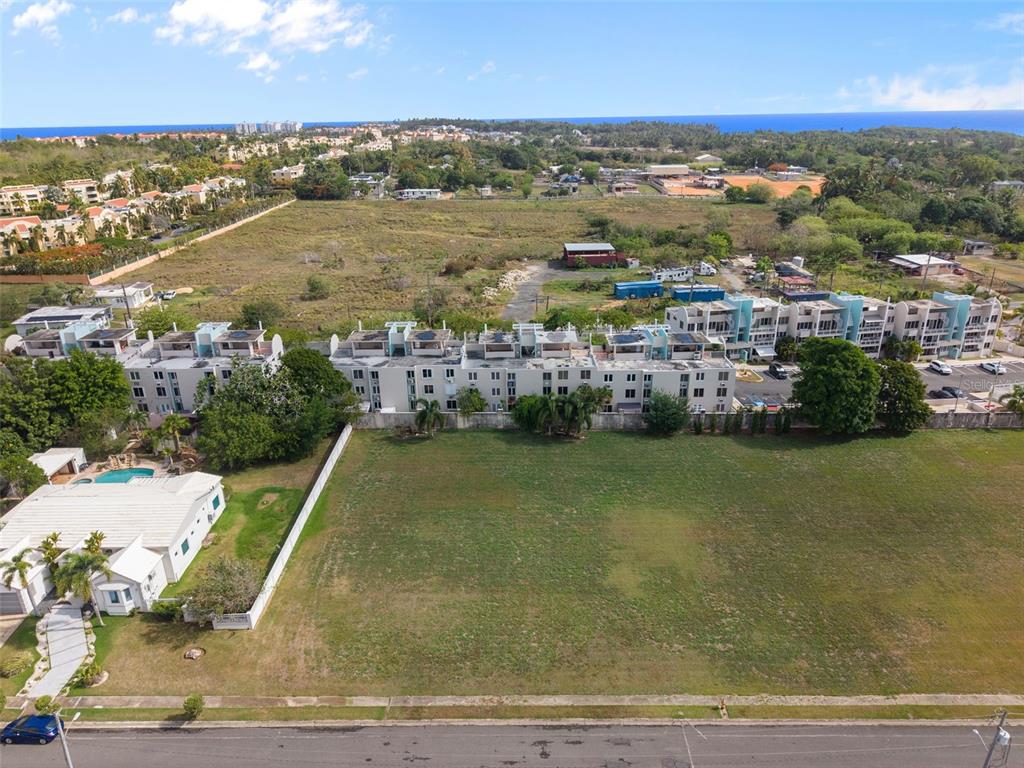 An aerial view shows a large vacant lot in front of a multi-story residential complex — G8 CALLE 2, VEGA ALTA, PR