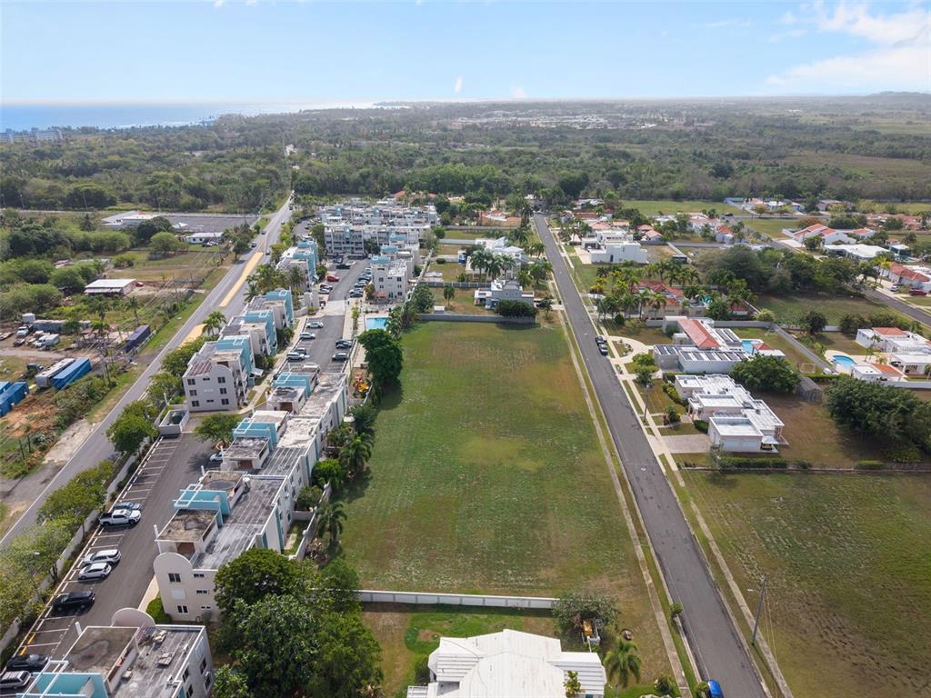 An aerial view shows a large vacant lot situated between two residential streets and buildings — G8 CALLE 2, VEGA ALTA, PR