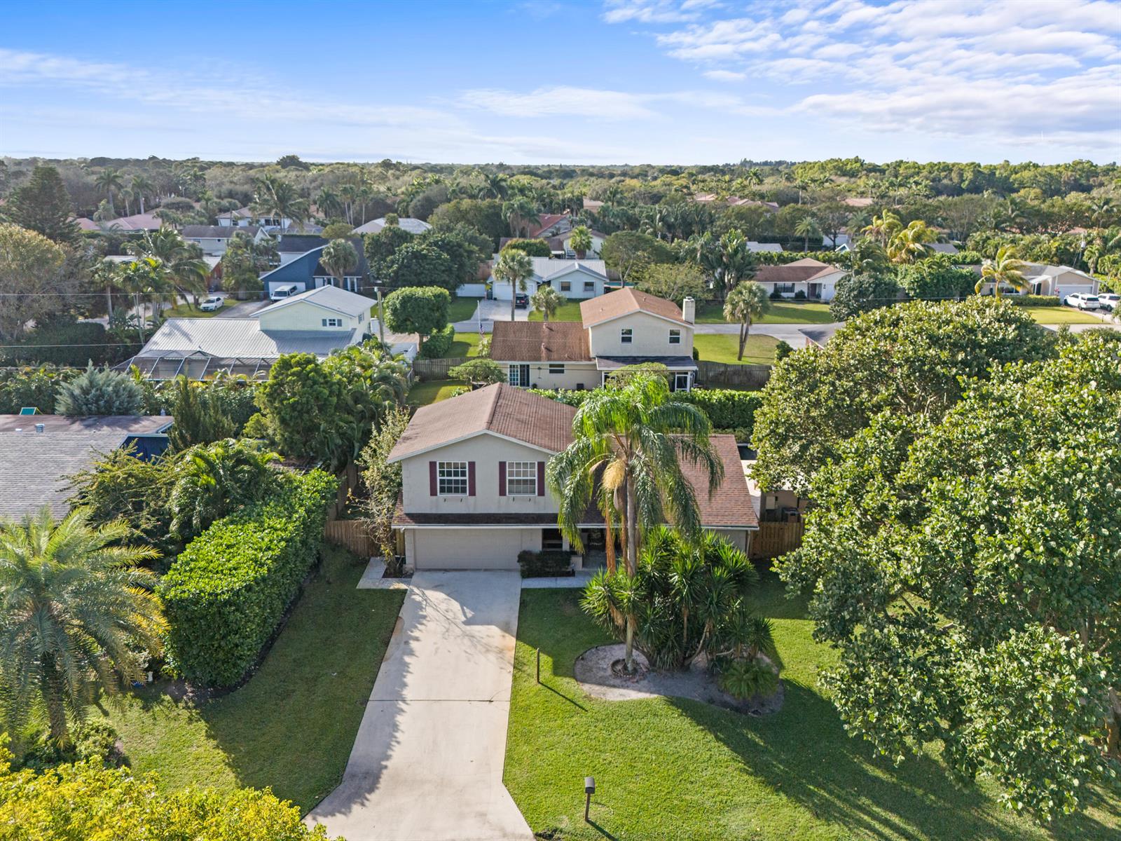 An aerial view shows a two-story suburban house with a driveway and palm trees — 4610 Pinetree Drive, Delray Beach FL 33445, DELRAY BEACH, FL