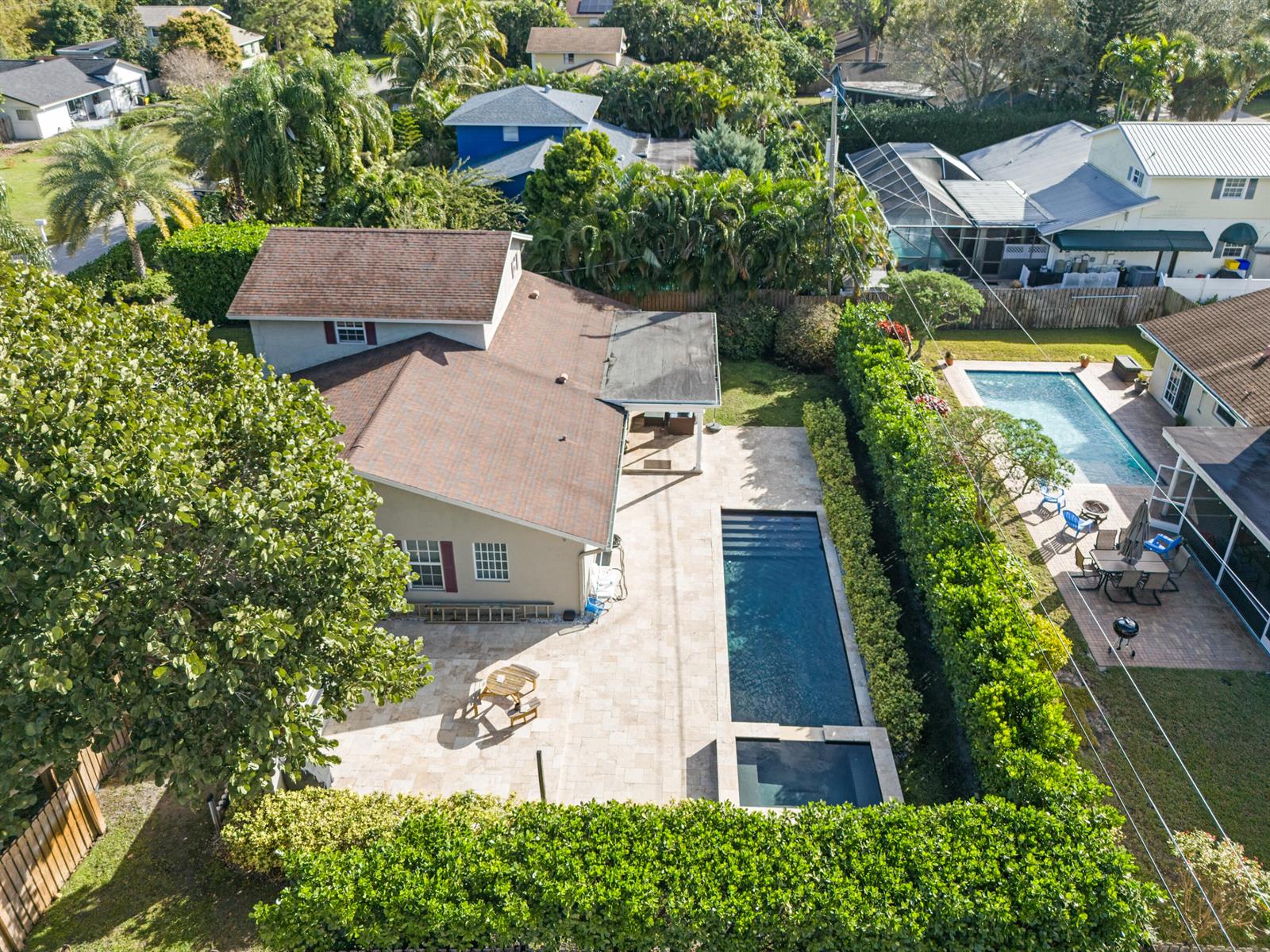 An aerial view shows a house with a patio, a rectangular pool, and a spa — 4610 Pinetree Drive, Delray Beach FL 33445, DELRAY BEACH, FL