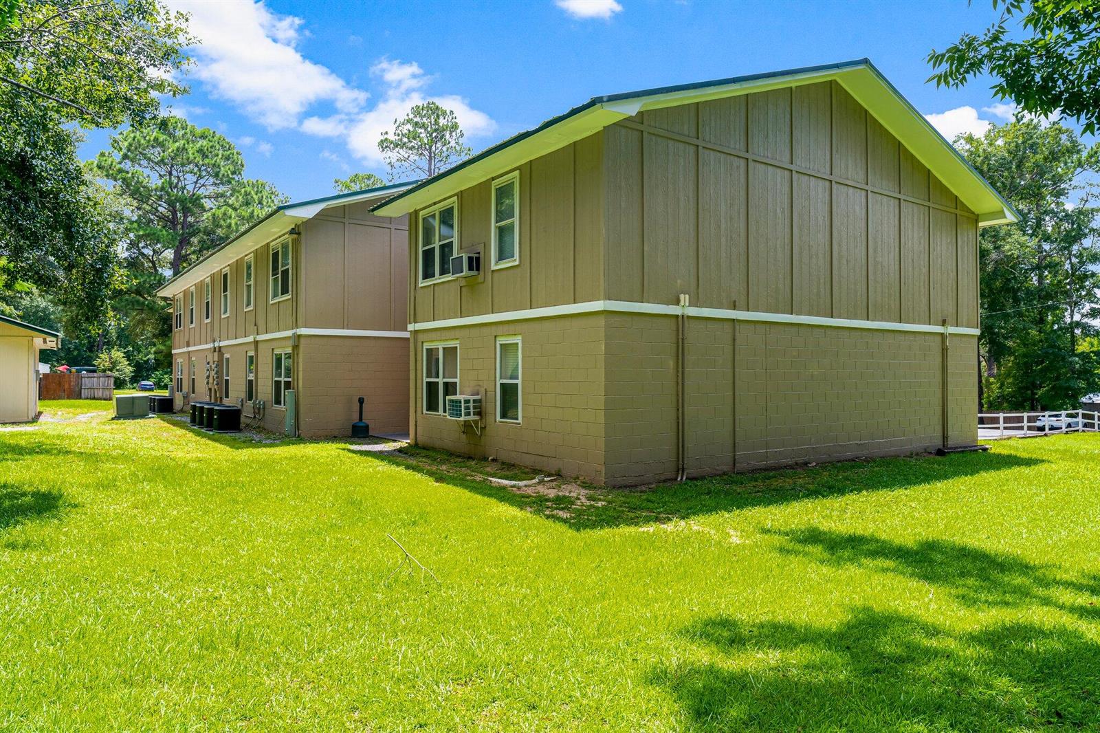 A two-story apartment building with tan siding and a block foundation sits on a lawn — 872 Deer Wood Lane, FL 32428, FL