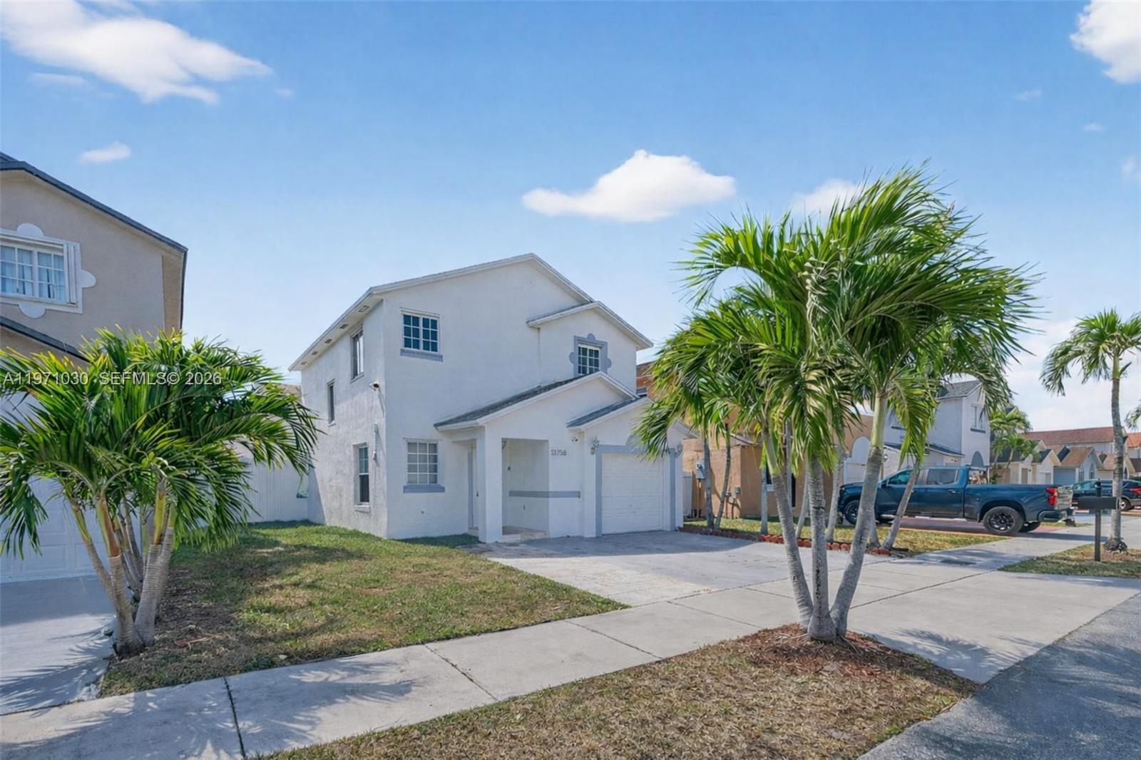A two-story white stucco house with a front-facing garage and palm trees in the yard — 13758 SW 160th Ter, Miami FL 33177, MIAMI, FL