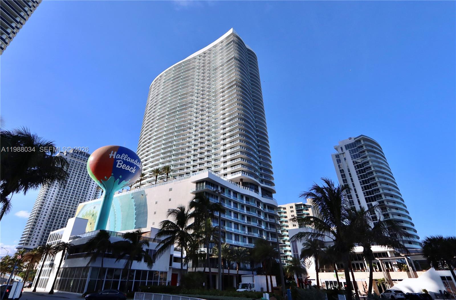 A tall modern residential tower stands next to a large Hallandale Beach water tower — 4111 S Ocean Dr, Hollywood FL 33019, HOLLYWOOD, FL