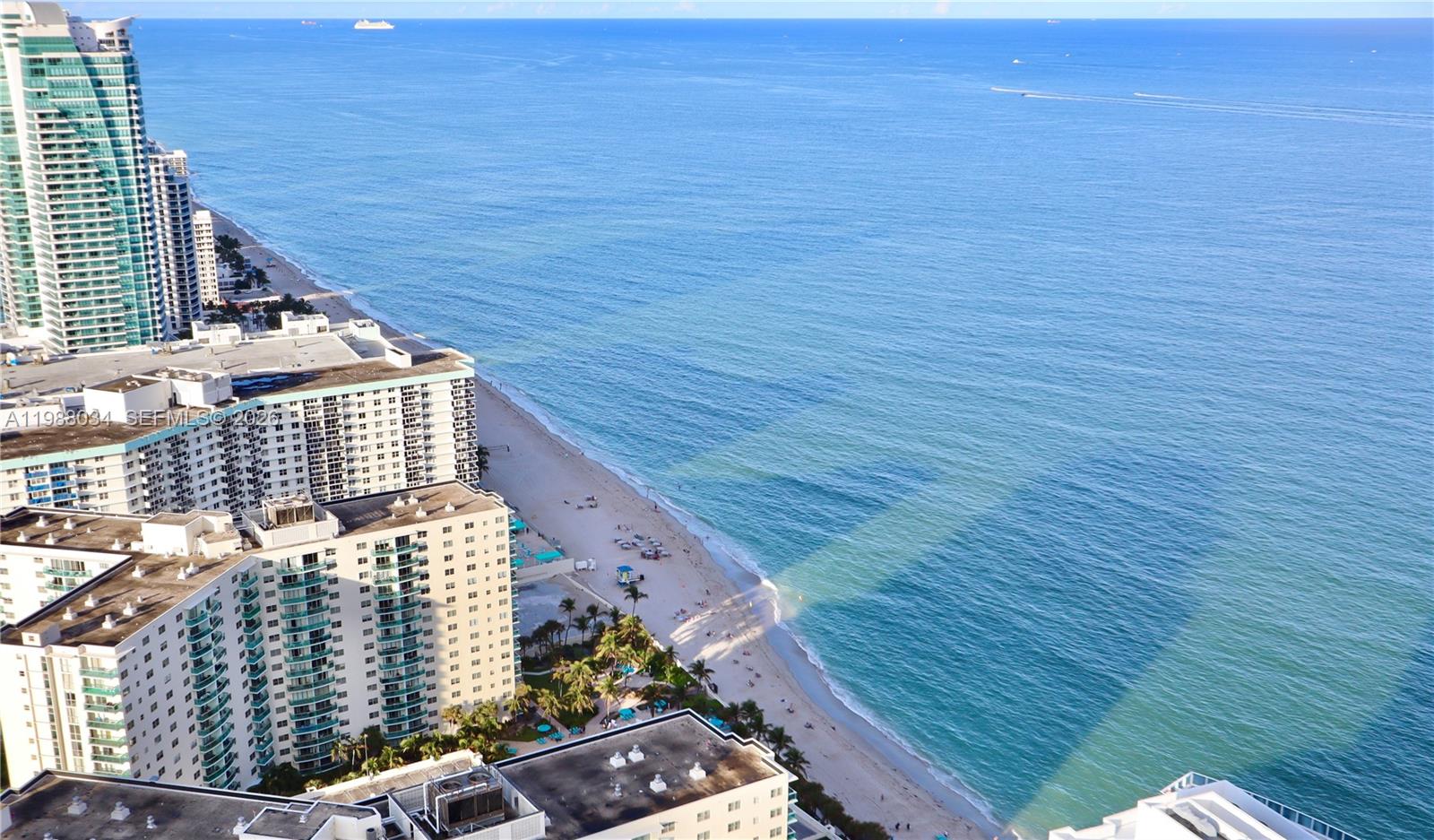 An aerial view shows a sandy beach, the ocean, and several high-rise residential buildings — 4111 S Ocean Dr, Hollywood FL 33019, HOLLYWOOD, FL