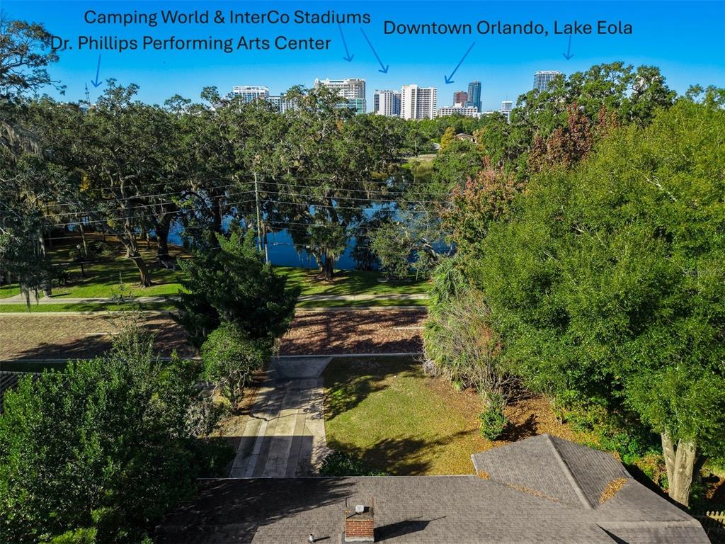 An aerial view shows a residential property overlooking a lake with the Orlando skyline beyond — 109 S BROWN AVENUE, ORLANDO, FL