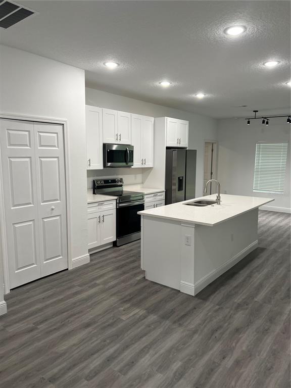 A modern kitchen features white cabinetry, stainless steel appliances, and a central island — 4455 SE 24TH STREET, OCALA, FL